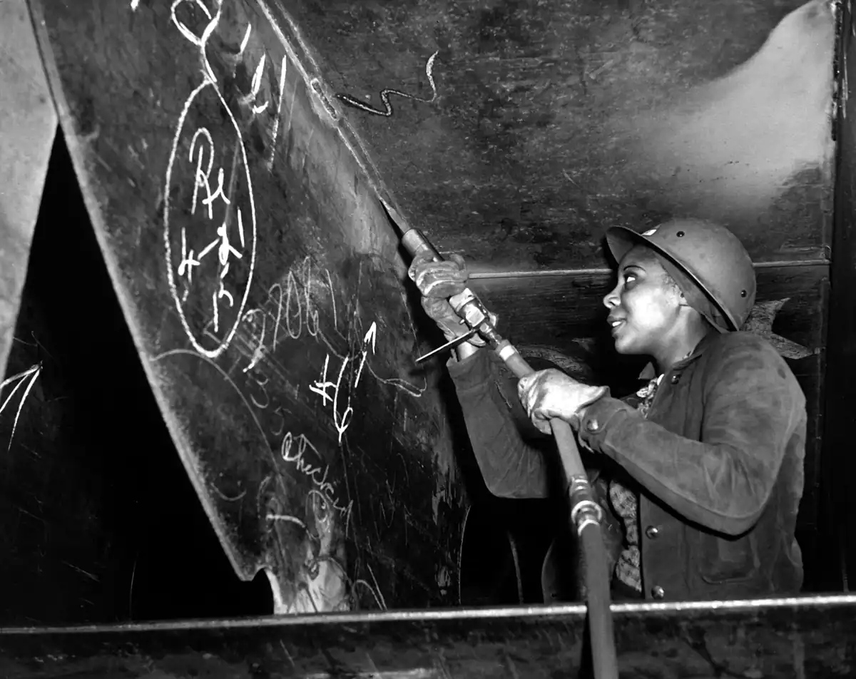 A welder working on a Liberty ship hull at the Kaiser shipyards, Richmond, California, 1943